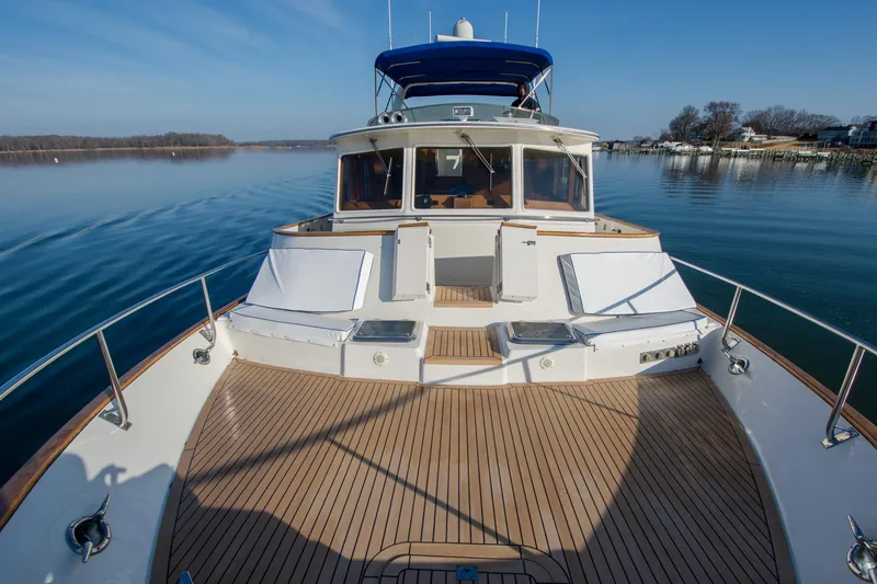 Slide: The Image of Luxurious 2000 Fleming 55 yacht on calm water, featuring spacious deck and seating. - 44