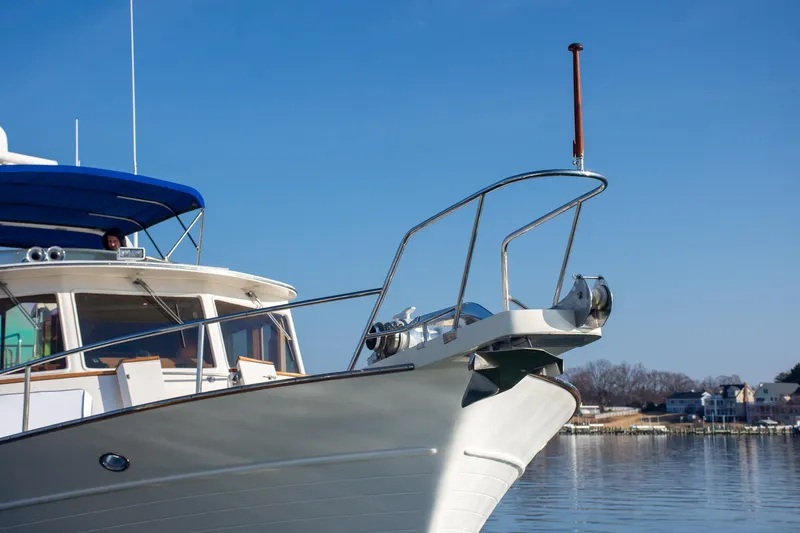 Slide: The Image of Fleming 55 yacht from 2000, featuring sleek design and blue canopy, on calm water. - 47