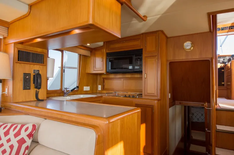 Slide: The Image of Luxurious 2000 Fleming 55 yacht interior with wood cabinetry and modern kitchen amenities. - 6