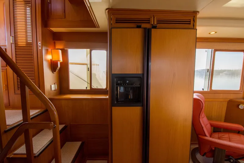 Slide: The Image of Interior of 2000 Fleming 55 yacht with wooden cabinetry and red leather chair. - 9