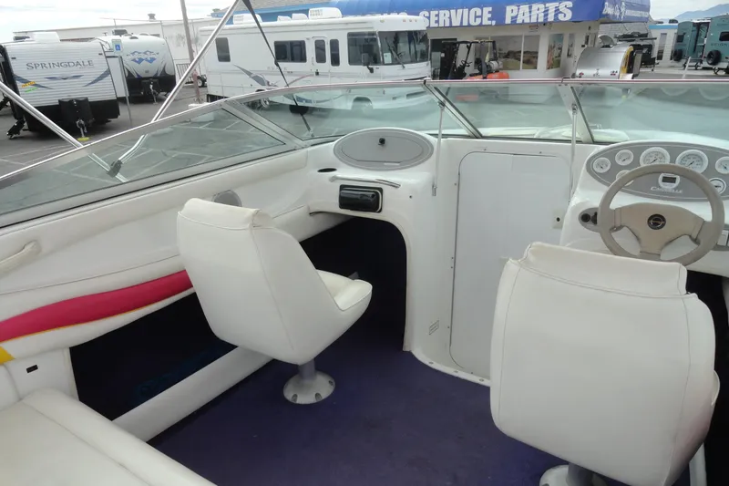 Slide: The Image of Interior of a 1997 Caravelle Interceptor 232 boat with white seating and dashboard. - 12