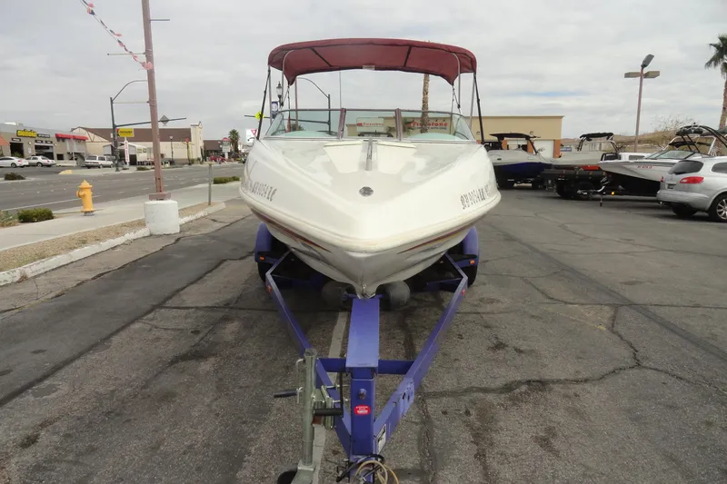 Slide: The Image of 1997 Caravelle Interceptor 232 boat on trailer, parked in urban setting. - 3