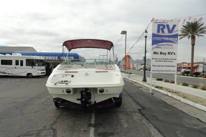 Slide: The Image of 1997 Caravelle Interceptor 232 boat parked near RV service center, overcast sky. - 6