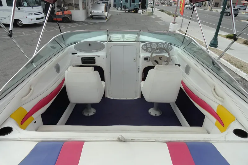 Slide: The Image of 1997 Caravelle Interceptor 232 boat interior with white seats and colorful accents. - 7