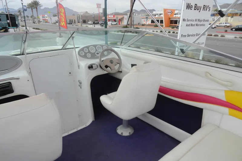 Slide: The Image of Interior of a 1997 Caravelle Interceptor 232 boat with white seating and dashboard. - 8