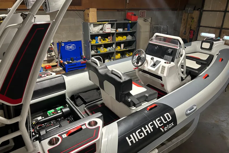 Slide: The Image of 2026 Highfield VELOX 560 boat interior with modern controls and seating in a workshop setting. - 2