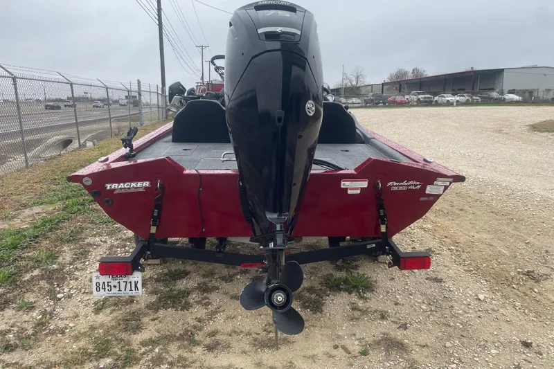 Slide: The Image of 2021 Tracker Pro Team 175 TXW boat with outboard motor, parked on gravel. - 2