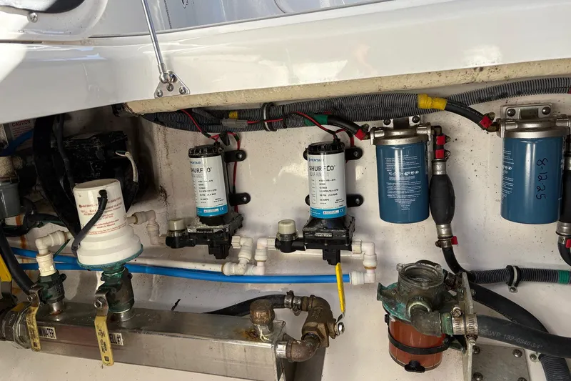 Slide: The Image of Engine compartment of a 2017 Everglades 350LX boat, showcasing pumps and filters. - 12