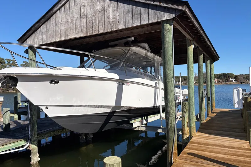 Slide: The Image of 2017 Everglades 350LX boat docked under wooden shelter by the water. - 15