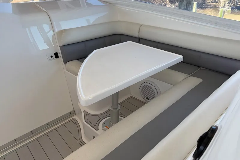 Slide: The Image of 2017 Everglades 350LX boat interior with cushioned seating and a white table. - 2