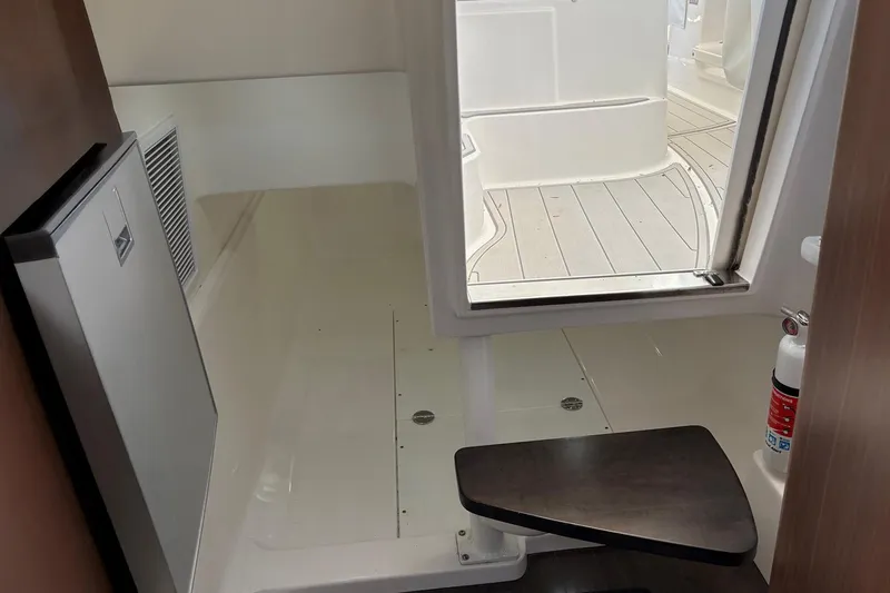 Slide: The Image of 2017 Everglades 350LX interior with fridge, seating, and fire extinguisher. - 3