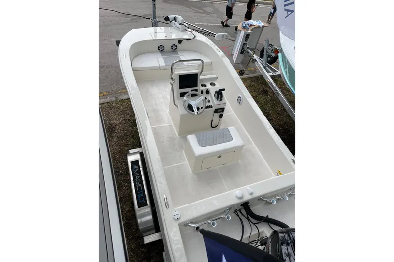 Slide: The Image of 2024 BlueCat 17 boat interior with steering console and seating, displayed outdoors. - 11