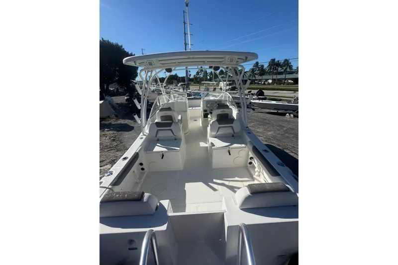 Slide: The Image of 2017 World Cat 255 DC boat interior with seating and helm, parked outdoors. - 3