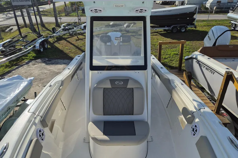 Slide: The Image of 2026 Key West 239 FS boat interior with seating and console, docked outdoors. - 10