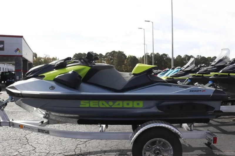 Slide: The Image of 2024 Sea-Doo RXP-X 325 jet ski on trailer, parked outdoors. - 13