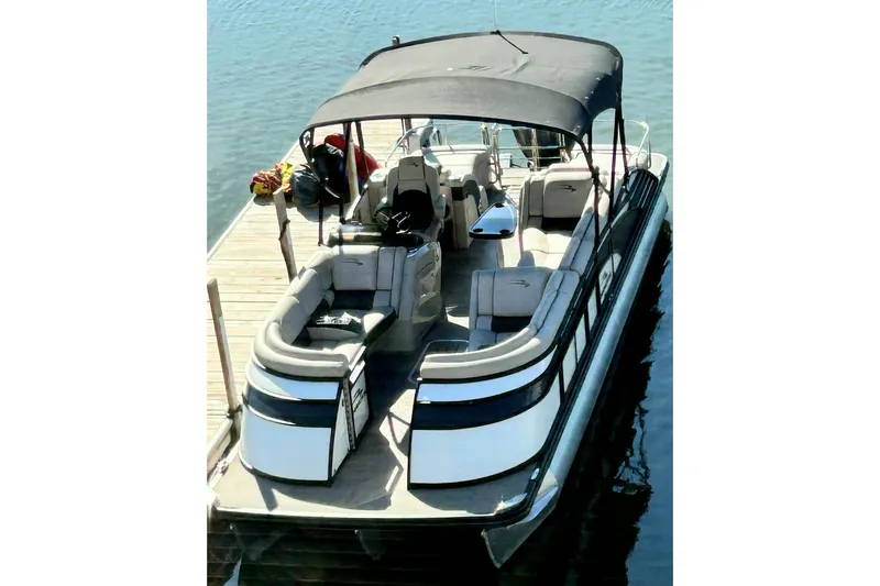 The Image of 2018 Bennington 25 QCW pontoon boat docked on calm water. - 0