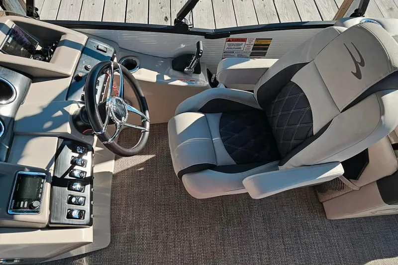 Slide: The Image of 2018 Bennington 25 QCW boat interior with steering wheel and captain's chair. - 11