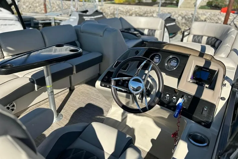 Slide: The Image of 2018 Bennington 25 QCW boat interior with steering wheel and seating area. - 13