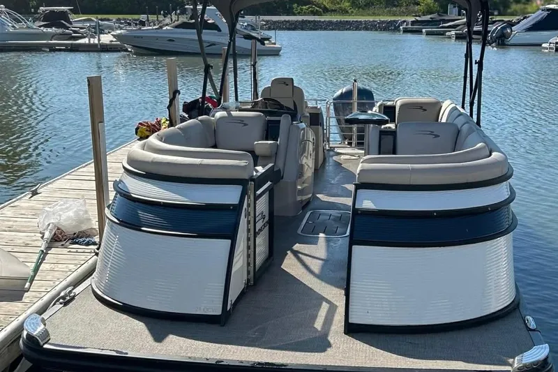 Slide: The Image of 2018 Bennington 25 QCW pontoon boat docked at a marina. - 2
