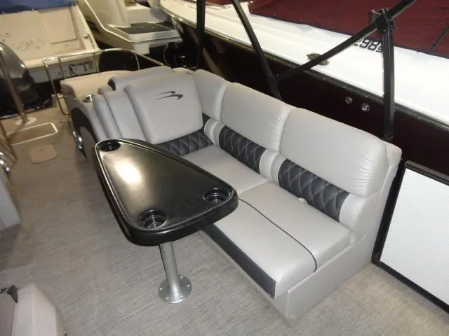 Slide: The Image of Interior of a 2018 Bennington 25 QCW with gray seating and table. - 26