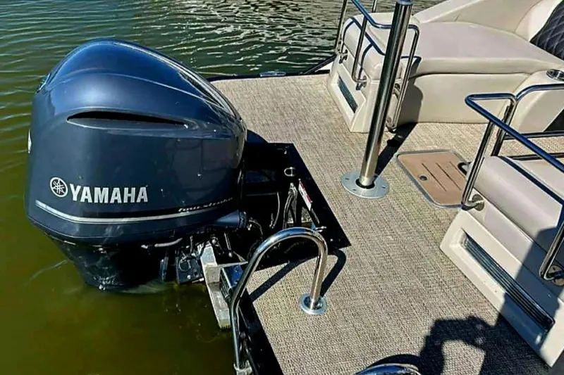 Slide: The Image of 2018 Bennington 25 QCW pontoon boat with Yamaha outboard motor on calm water. - 5