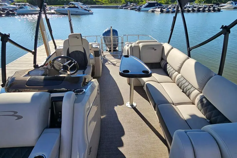 Slide: The Image of 2018 Bennington 25 QCW pontoon boat with luxurious seating and sleek design at a dock. - 9