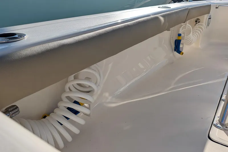Slide: The Image of 2014 Key West 246 Bay Reef boat interior with coiled hose and padded rail. - 17
