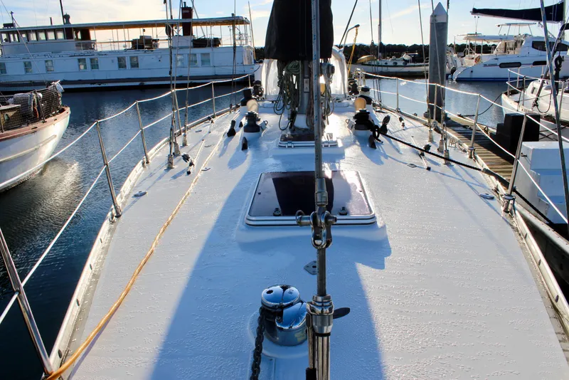 Slide: The Image of 1973 Nautor Swan 44 sailboat deck view in marina, showcasing rigging and moored vessels. - 12
