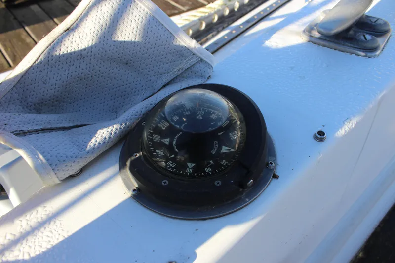 Slide: The Image of Compass on 1973 Nautor Swan 44 yacht deck, with textured fabric nearby. - 24