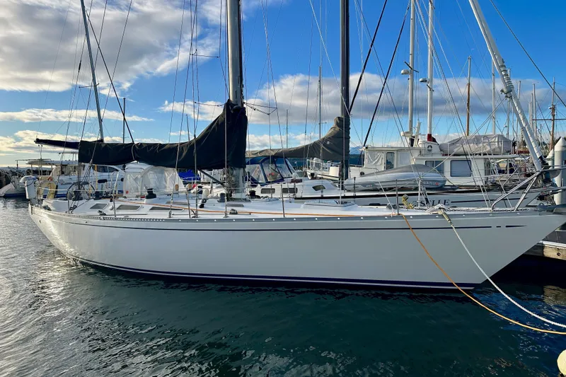 Slide: The Image of 1973 Nautor Swan 44 sailboat docked in a marina under a blue sky. - 3