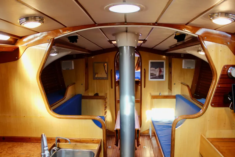 Slide: The Image of Interior of a 1973 Nautor Swan 44 yacht with wooden finish and blue seating. - 34
