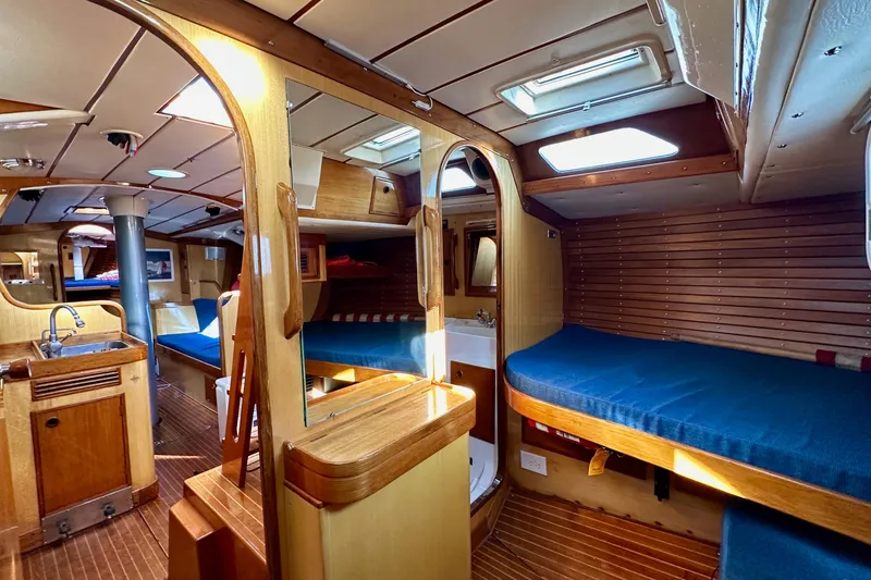 Slide: The Image of Interior of 1973 Nautor Swan 44 yacht, featuring wooden finishes and blue upholstery. - 53