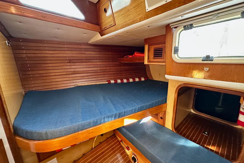 Slide: The Image of Cozy cabin interior of 1973 Nautor Swan 44 sailboat with wooden finish and blue bedding. - 54