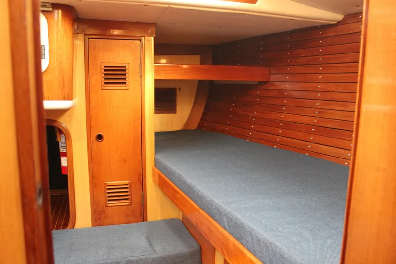 Slide: The Image of Interior of 1973 Nautor Swan 44 yacht with wooden paneling and blue cushions. - 55