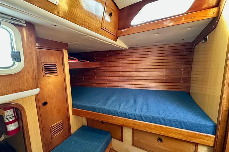 Slide: The Image of Cozy cabin interior of 1973 Nautor Swan 44 sailboat with wooden finish and blue bedding. - 59
