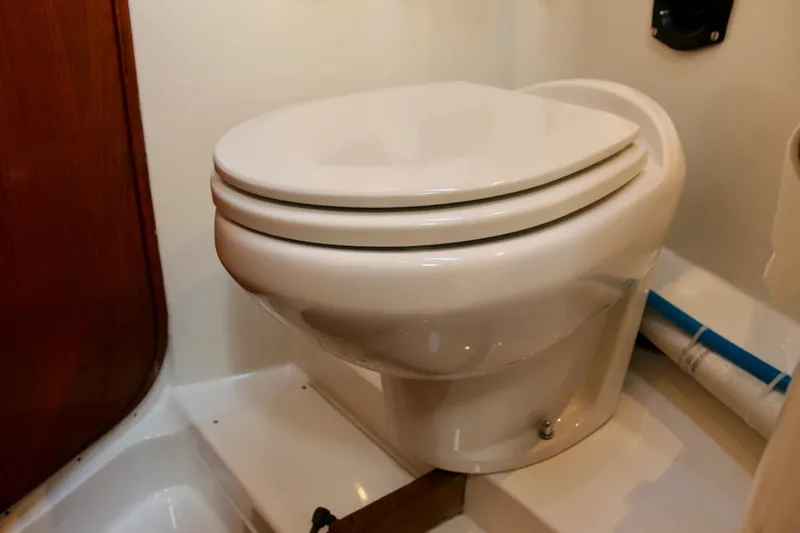 Slide: The Image of Toilet in 1973 Nautor Swan 44 yacht bathroom, featuring white fixtures and wooden accents. - 66