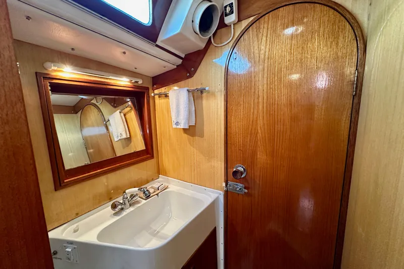Slide: The Image of Vintage 1973 Nautor Swan 44 yacht bathroom with wooden door, mirror, and sink. - 67