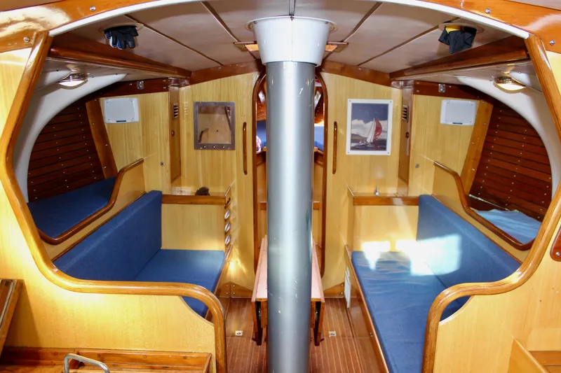 Slide: The Image of Interior of a 1973 Nautor Swan 44 sailboat with wooden finish and blue seating. - 68