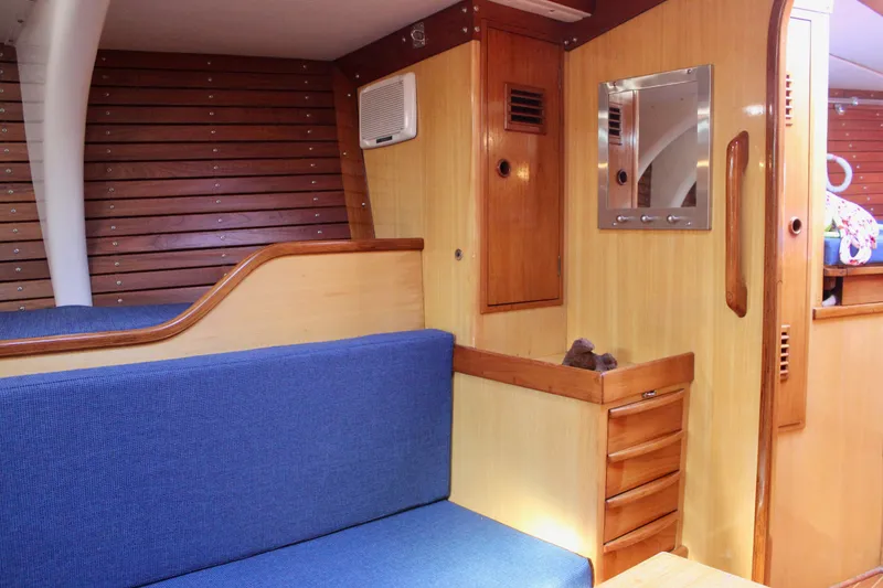 Slide: The Image of Interior of 1973 Nautor Swan 44 yacht with blue seating and wooden paneling. - 73