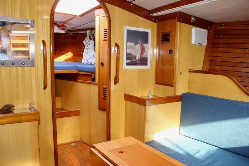 Slide: The Image of Interior of 1973 Nautor Swan 44 sailboat with wooden finish and blue seating. - 74