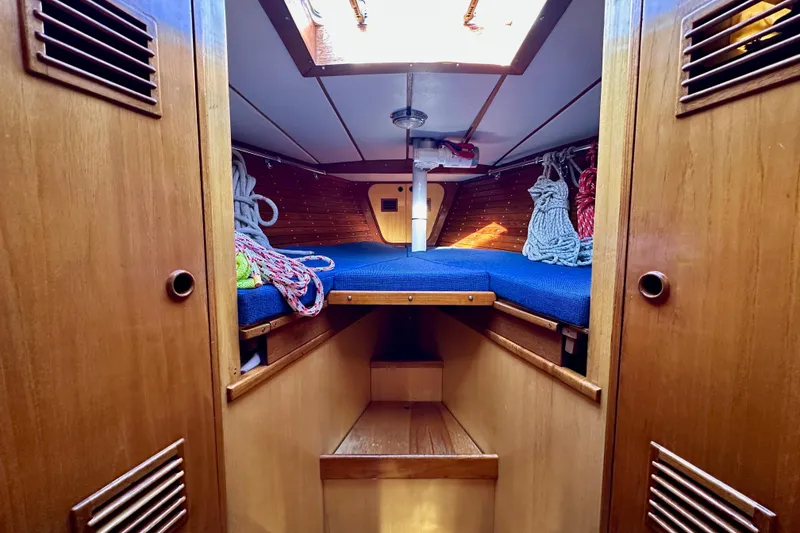 Slide: The Image of Cozy cabin interior of 1973 Nautor Swan 44 sailboat with wooden finish and blue bedding. - 76