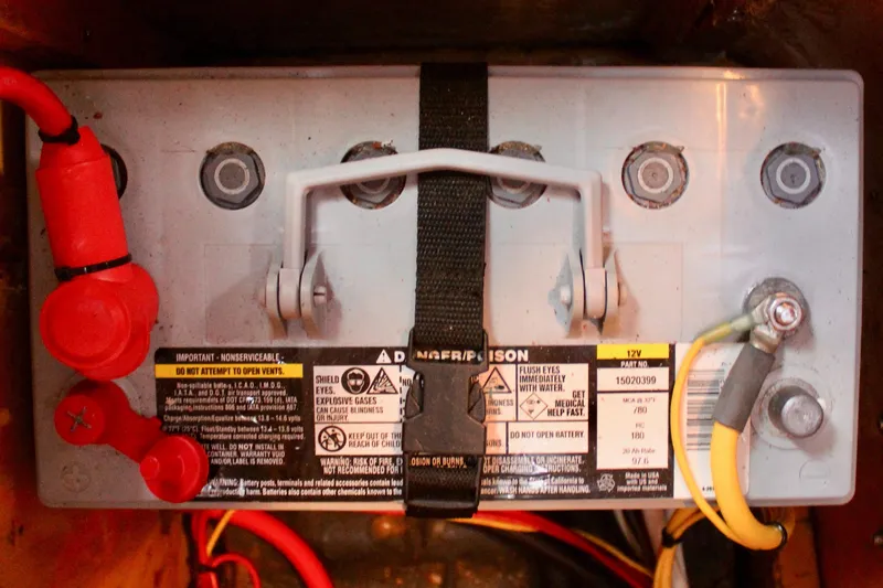 Slide: The Image of 12V battery in a 1973 Nautor Swan 44 sailboat, secured with straps and connected cables. - 85