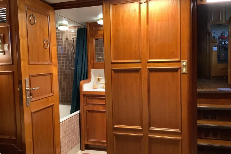 Slide: The Image of Wood-paneled bathroom interior on a 1974 Doggersbank 63 yacht, featuring a shower and vanity. - 12
