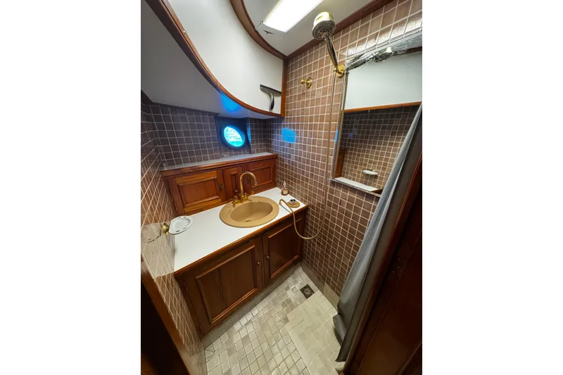Slide: The Image of 1974 Doggersbank 63 yacht bathroom with wooden cabinetry and tiled walls. - 13