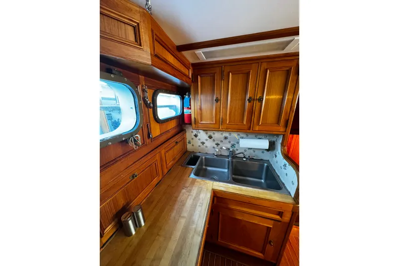 Slide: The Image of Wooden kitchen interior of 1974 Doggersbank 63 boat with double sink and porthole windows. - 15