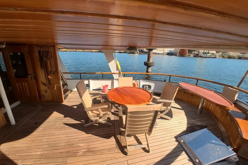 Slide: The Image of Wooden deck of 1974 Doggersbank 63 yacht with chairs and tables overlooking water. - 20