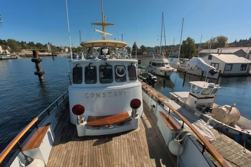 Slide: The Image of 1974 Doggersbank 63 yacht "Constant" docked at marina, surrounded by boats and clear blue sky. - 31