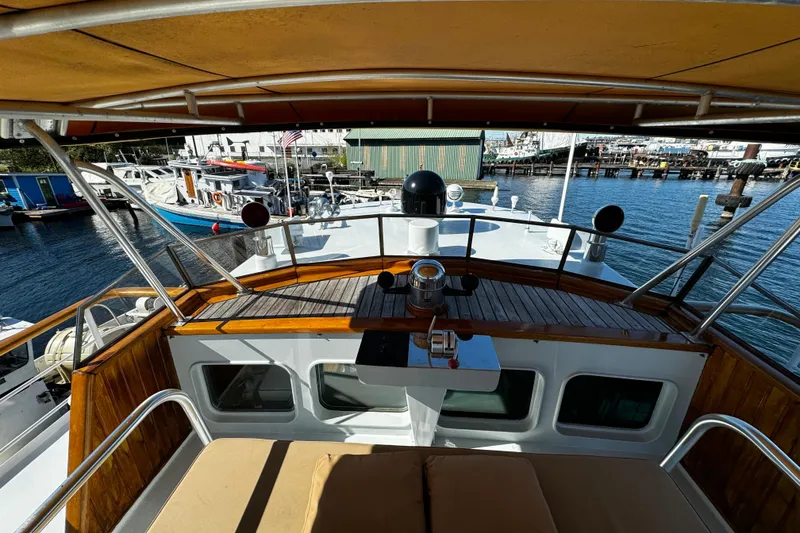 Slide: The Image of 1974 Doggersbank 63 yacht deck with wooden accents and marina view. - 32