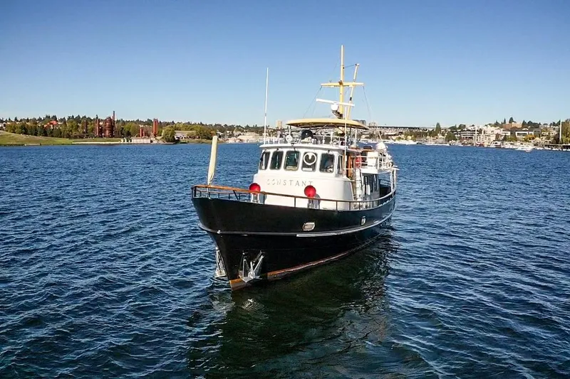 Slide: The Image of 1974 Doggersbank 63 yacht on a serene lake with clear blue skies. - 38