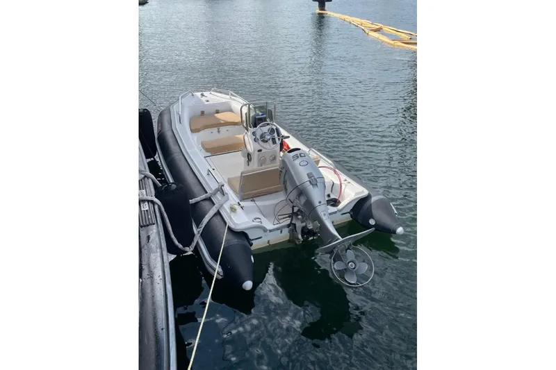 Slide: The Image of Small motorboat docked on calm water, featuring a 50 HP outboard engine. - 41